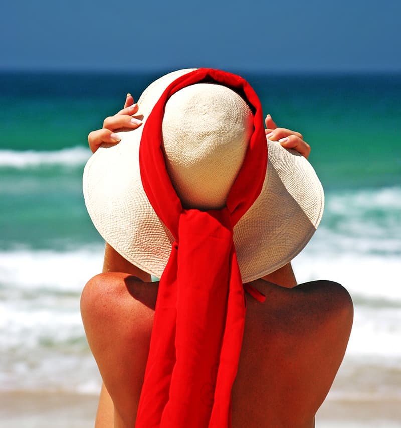 woman with hat on the beach